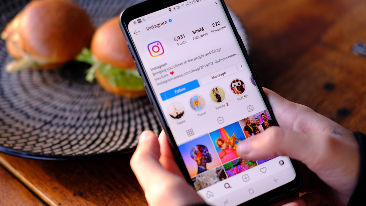 imagem de um smartphone sendo segurado enquanto o perfil do instagram está aberto